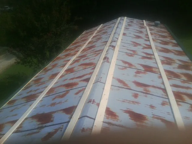 Rusted metal roof panels with new wood purlins before replacement — Storm Damage Roof Repair in Norman Park by Roofing Brothers