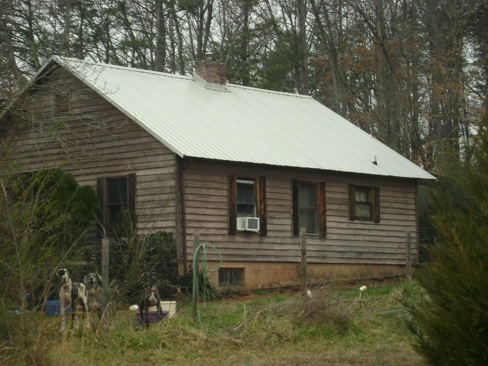 White metal roof on an old wood sided farmhouse, from a Metal Roof Installation job in Norman Park